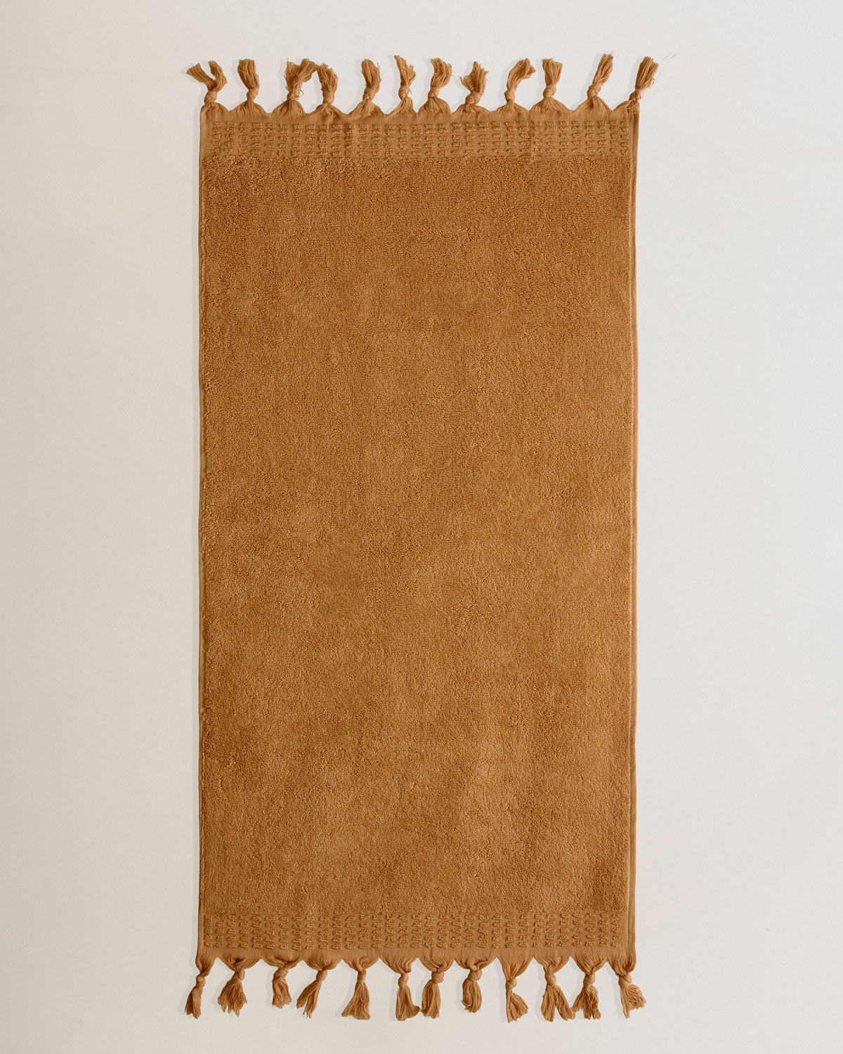 Serviette à franges unie 550 g ocre