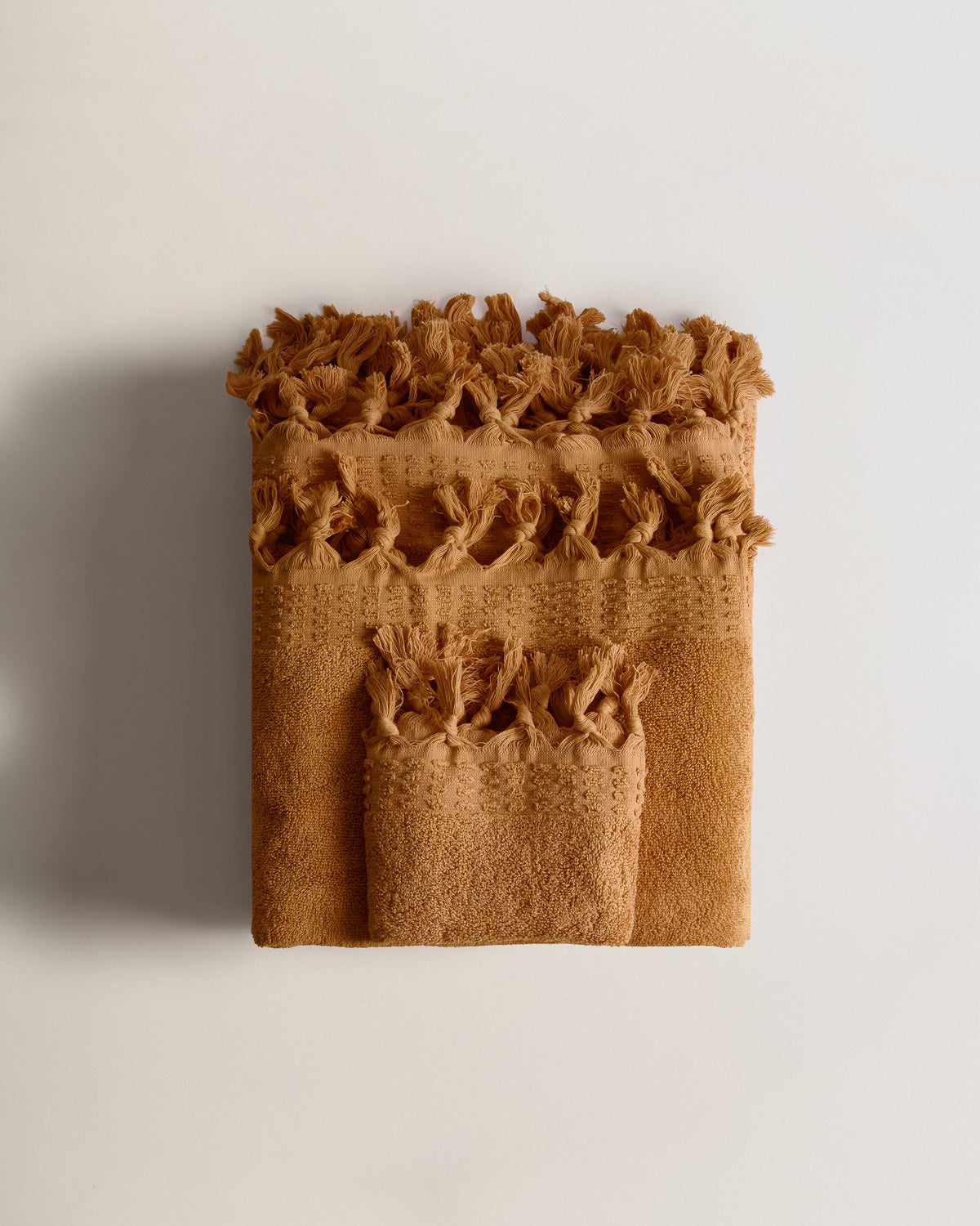 Serviette à franges unie 550 g ocre